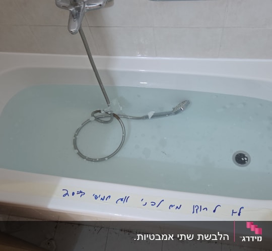 אמבטיה עם מים וצינור מקלחת